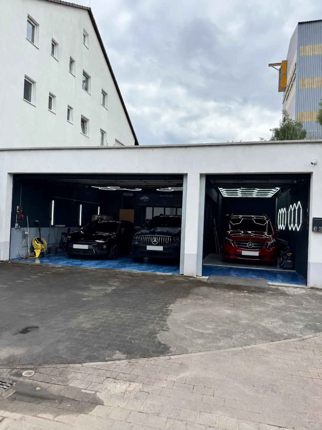 Offene Werkstatttore von AutoGlanzService in Kelsterbach mit Fahrzeugen in den Pflegeplätzen